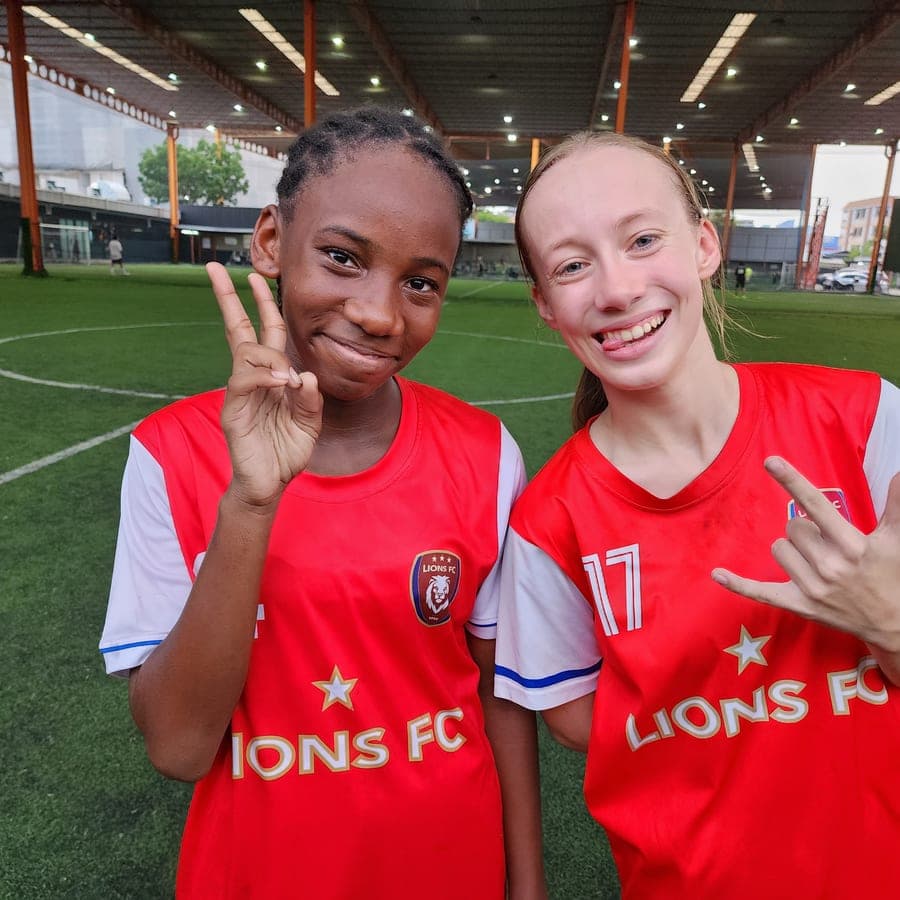 Two Lions FC players grinning at the camera after a session on the covered pitch